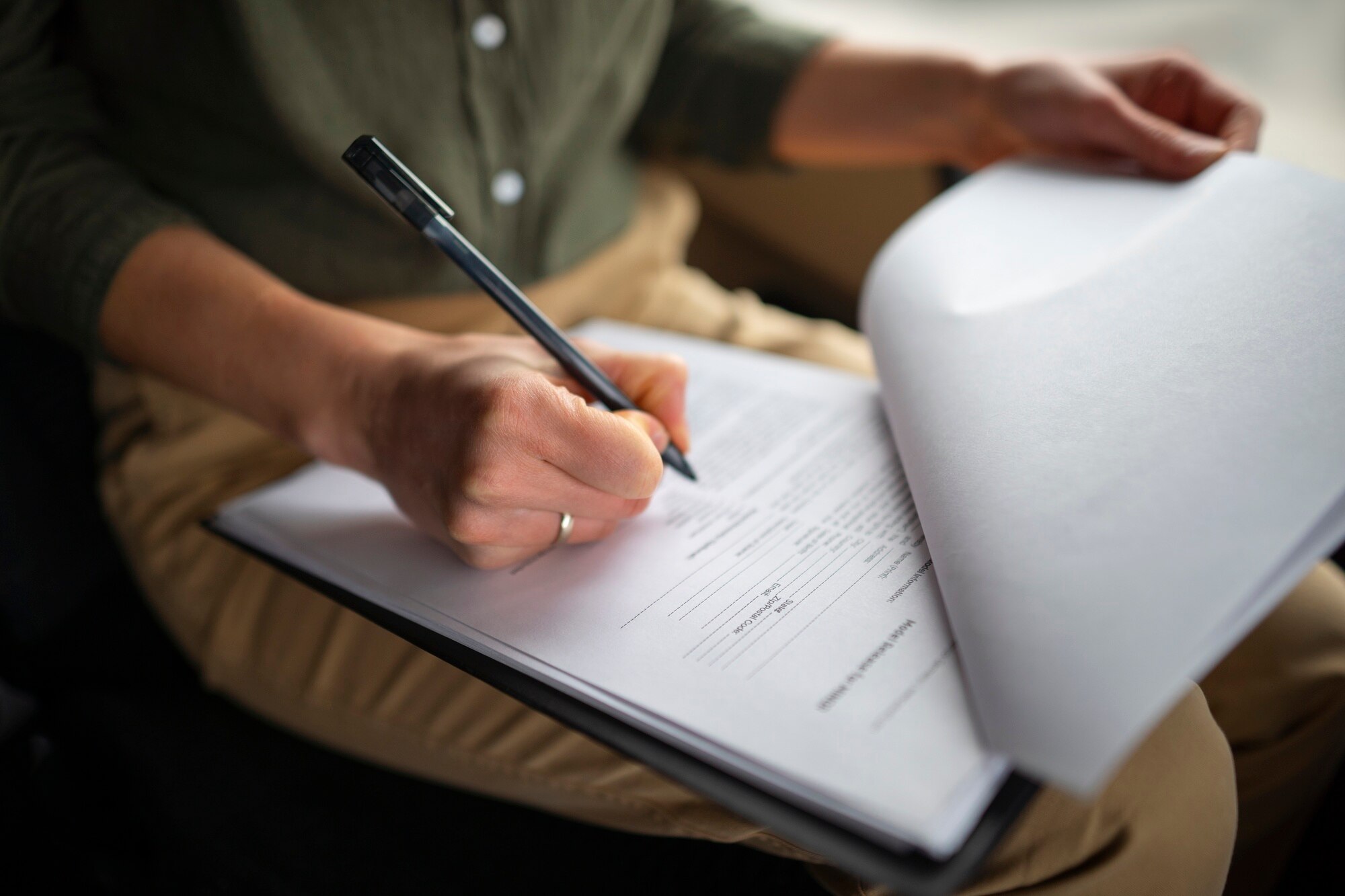 Primo piano di una mano firma un documento